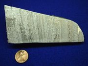Aluminium metal with a copper coin for size comparison